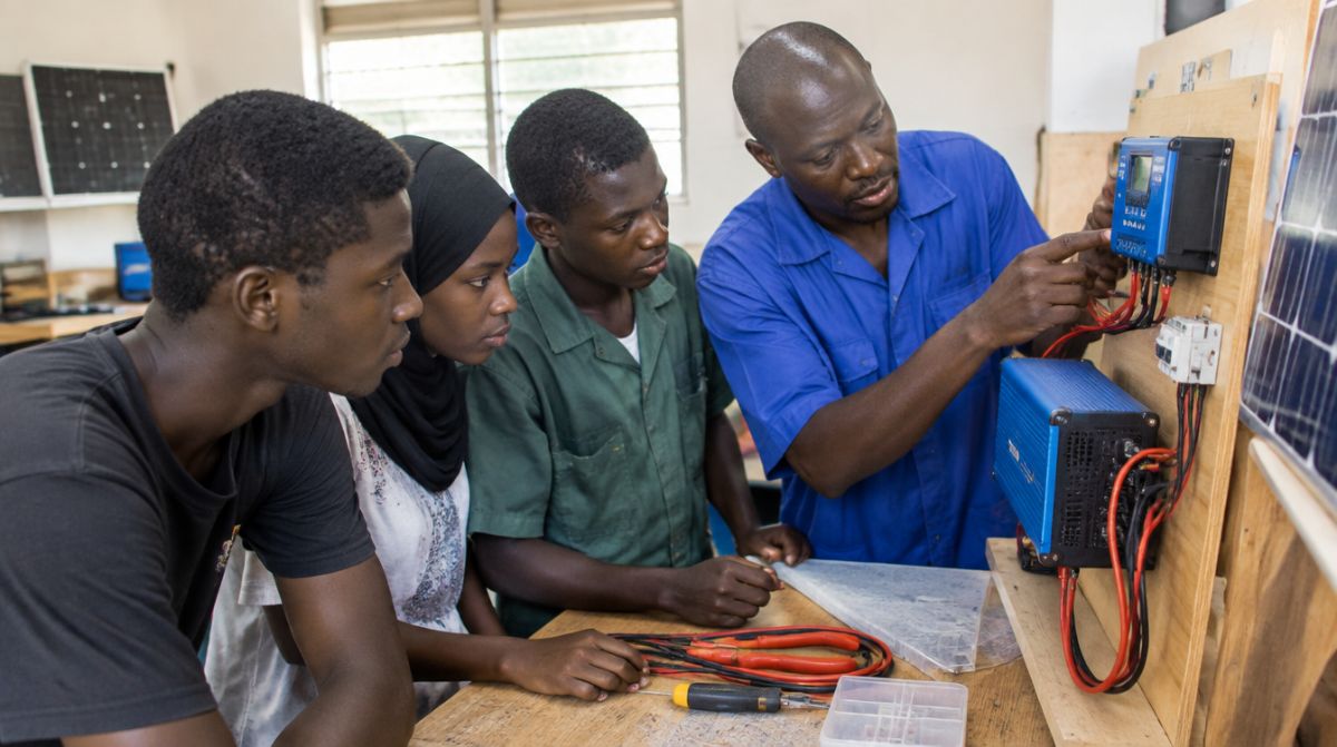 Instructor training apprentices to wire a solar inverter